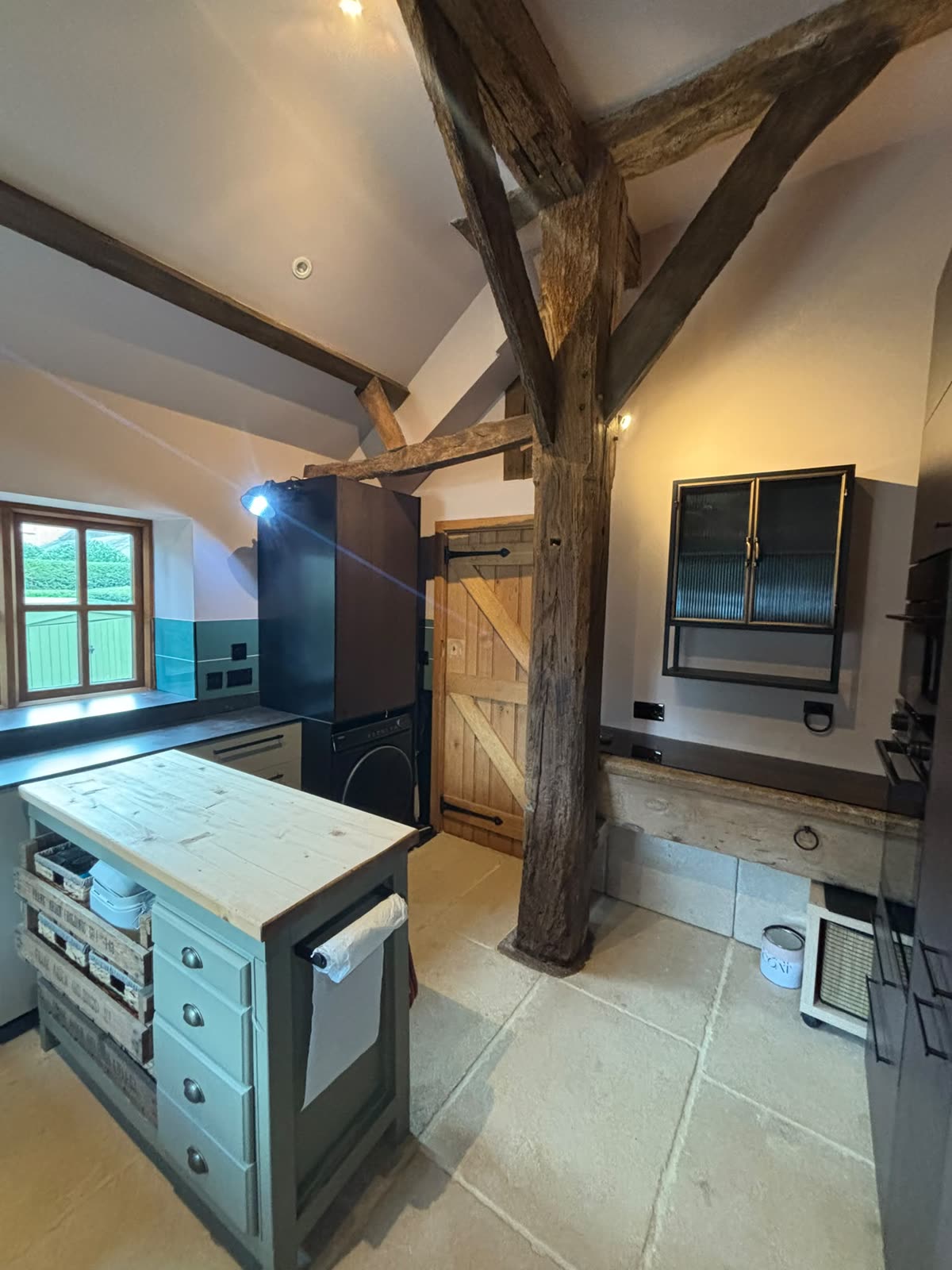 Barn conversion kitchen with oak beams and painted island